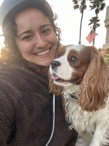 Woman with helmet and her Blenheim SD have a great time going cycling in Oxnard, CA.